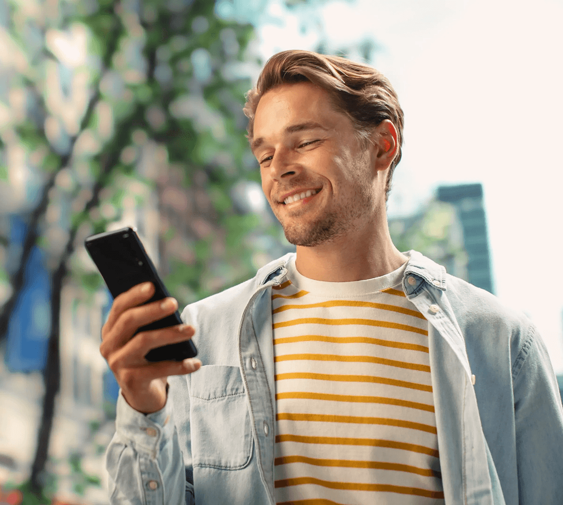 Fiatal férfi telefonját nézi.